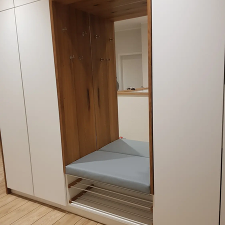 Ein großer weißer Schrank mit Sitzfunktion