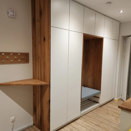 Ein großer weißer Schrank mit Sitzfunktion